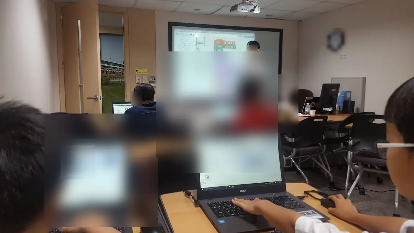 CIT 코딩 학원에서 학생들이 노트북으로 코딩을 실습하는 수업 현장 (개인정보 보호를 위해 얼굴은 비식별 처리). Students coding together during a class at CIT AI and coding academy in Apgujeong, faces masked for privacy