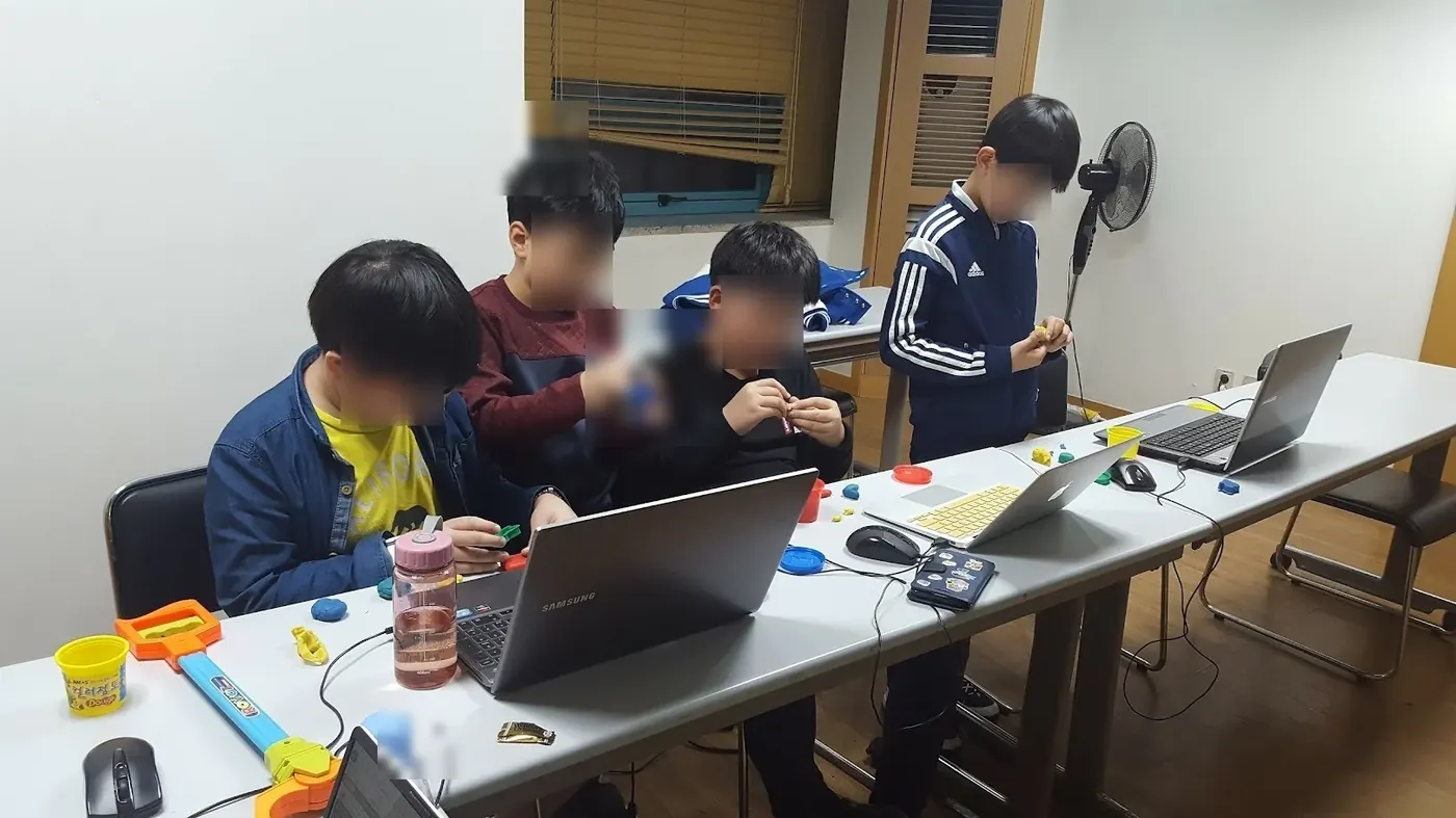 CIT 프로그램 수업에서 학생들이 함께 컴퓨팅 사고와 문제 해결을 실습하는 그룹 활동 (개인정보 보호를 위해 얼굴은 비식별 처리). Hands-on group activity in a CIT program, faces masked for privacy